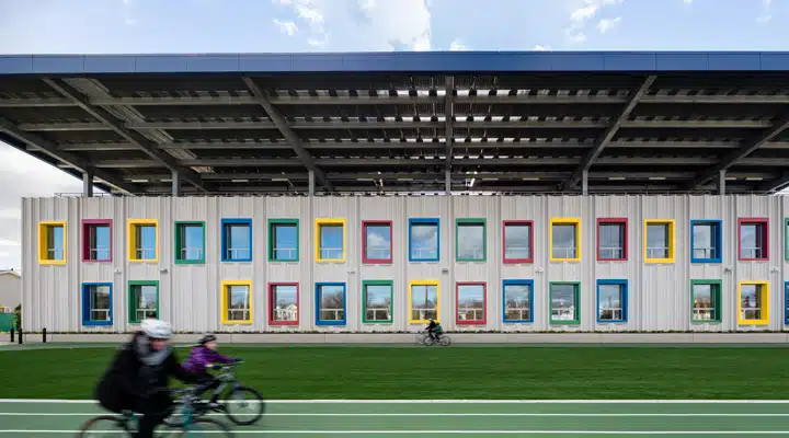 02_EWING-SOM-PS62-0083v2 A group of people playing football in front of a building