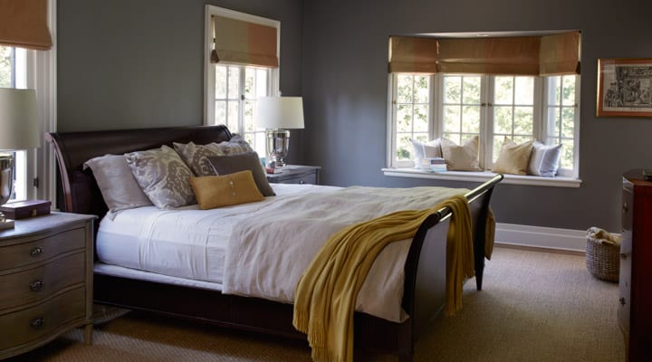 A bedroom with a bed and desk in a hotel room