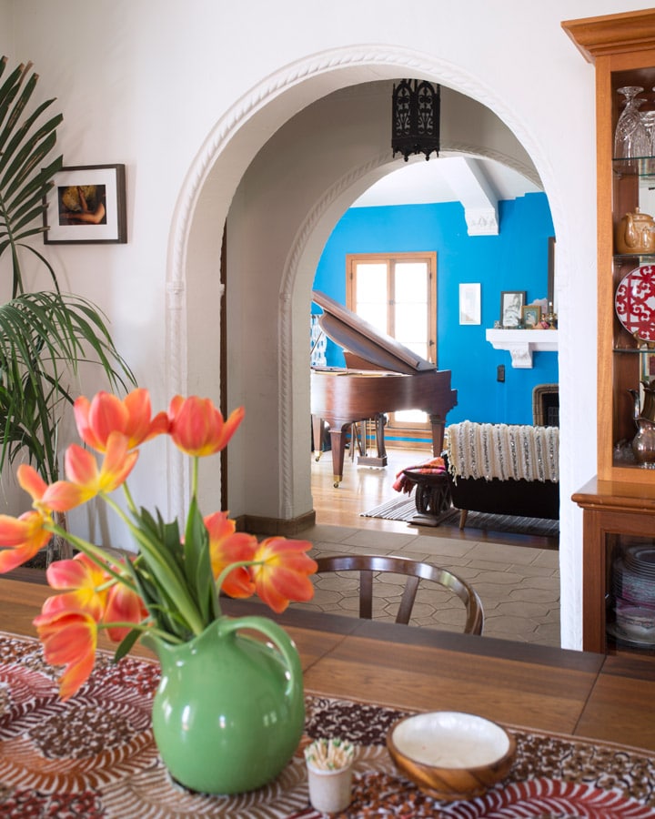 Una habitación llena de muebles y un jarrón de flores sobre una mesa