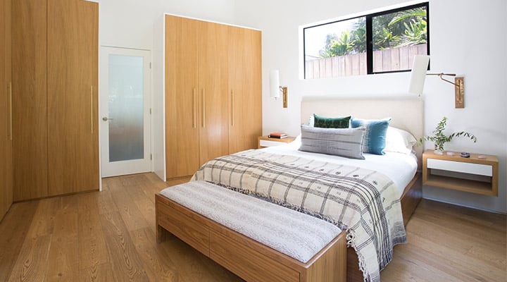 A bedroom with a bed and desk in a room