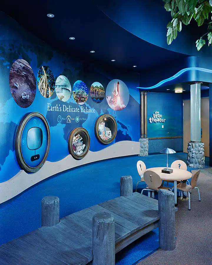 7f8071_51f21de3fd3a476ba8a8a59341d7ca7f A person in a blue chair in a room