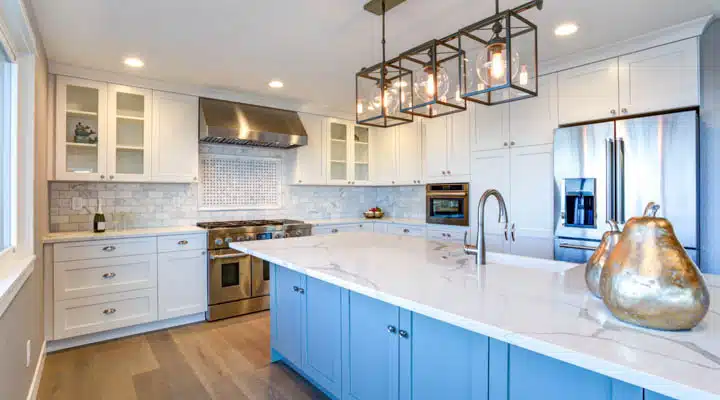 Beautiful white kitchen with large island. A large kitchen with stainless steel appliances