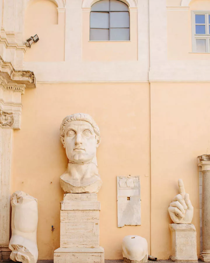 Sculptures in Rome A group of people sitting on the side of a building