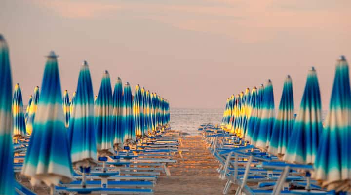 Un grupo de sillas de jardín sentadas encima de un sandy beach