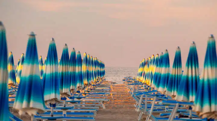Rimini beach A group of lawn chairs sitting on top of a sandy beach