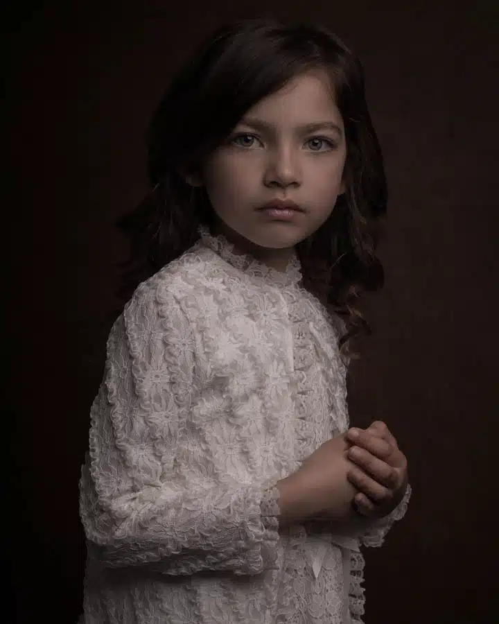 Girl in white with green eyes A little girl standing in front of it