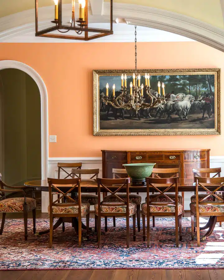 Orange peach colorful dining room with oriental rug and classic A dining room table
