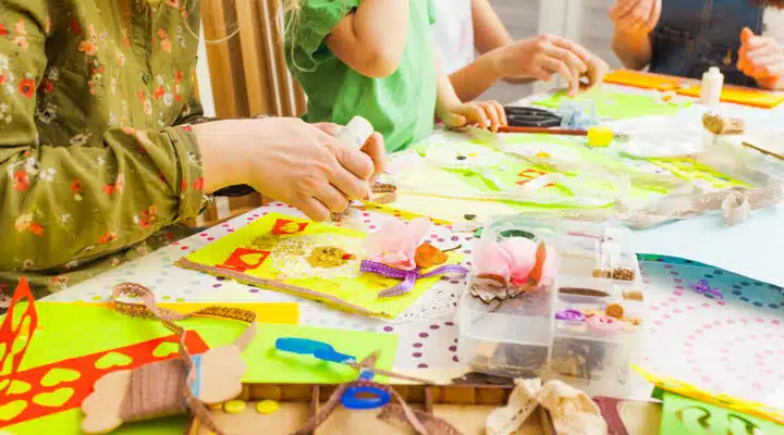 Children's art project, craft for children. Kids doing greeting card at creative workshop with teacher A young boy sitting at a table with a birthday cake