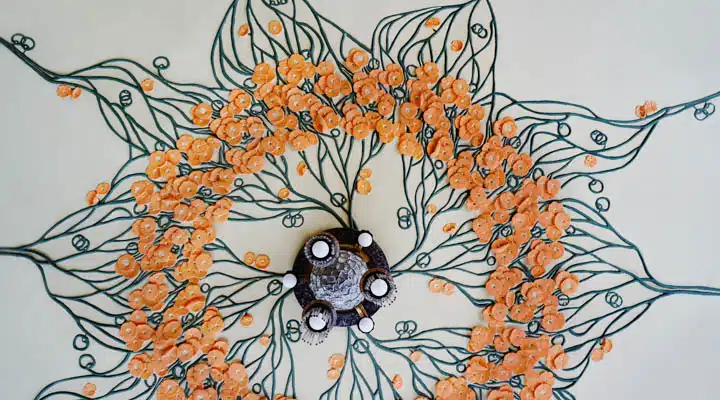 Details of decorated with bas-relief and painting ceiling. Art Nouveau interior style of the beginning of the XX century. Orange flowers painted at ceiling. A close up of a map