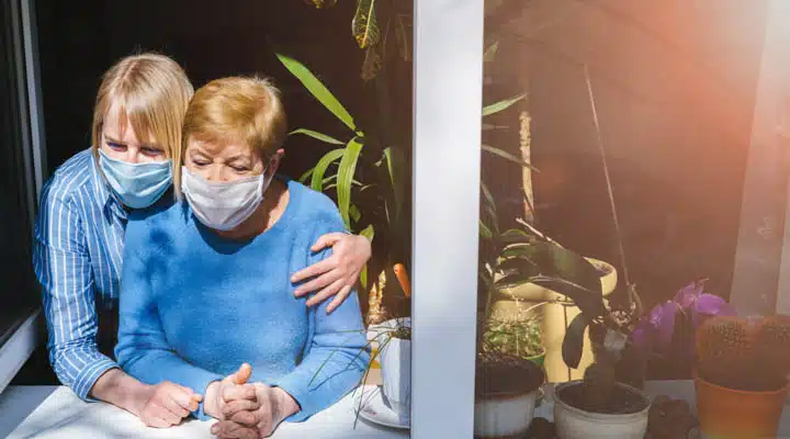 Two women, an old mother and her adult daughter sit together near the window A little girl sitting on a table
