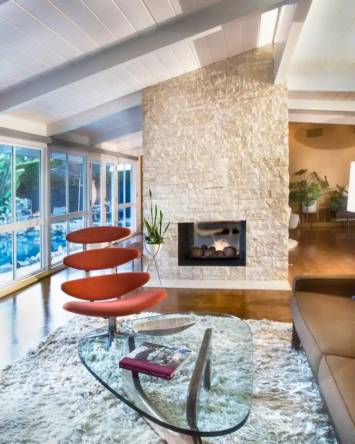 Cliff-May-1 Un salón lleno de muebles y una chimenea sentado en una silla