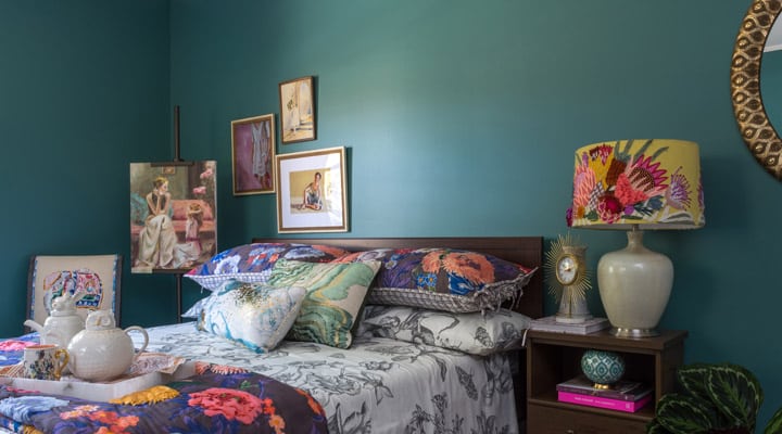 A room filled with furniture and vase of flowers sits on a bed