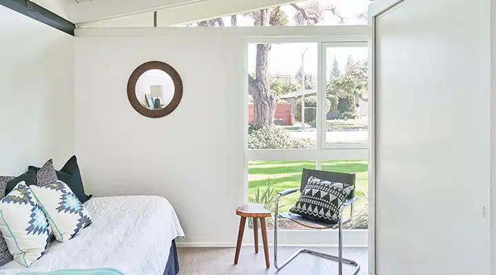 DunnEdwards_10312018_2292-720x400 A bedroom with a bed and a chair in a room