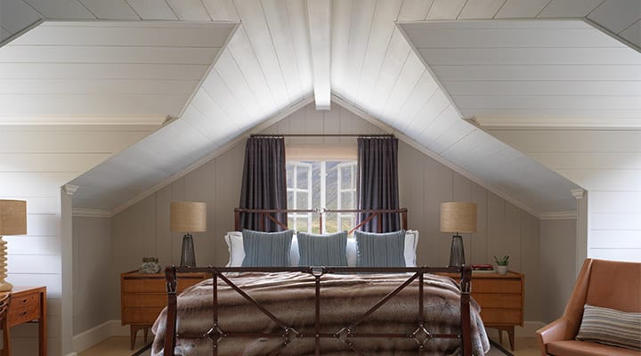 A bedroom with a bed and a chair in a room