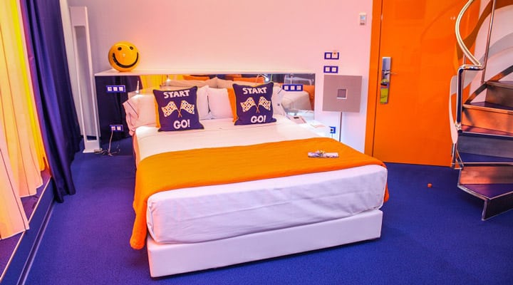 A bedroom with a bed and desk in a room
