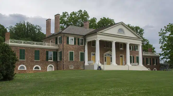 GettyImages-513053185_high A large brick building with grass in front of a house