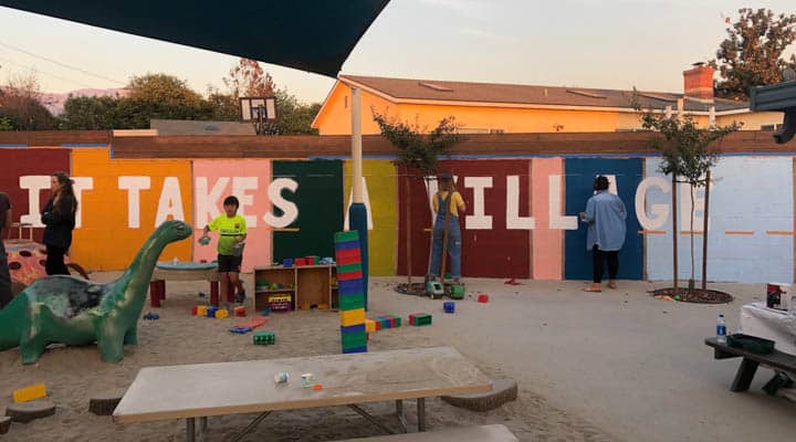 Un grupo de personas sentadas en una mesa frente a un edificio