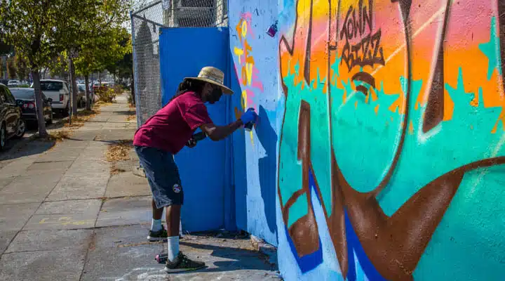 IMG_5978-720x400 A man standing next to a graffiti covered wall