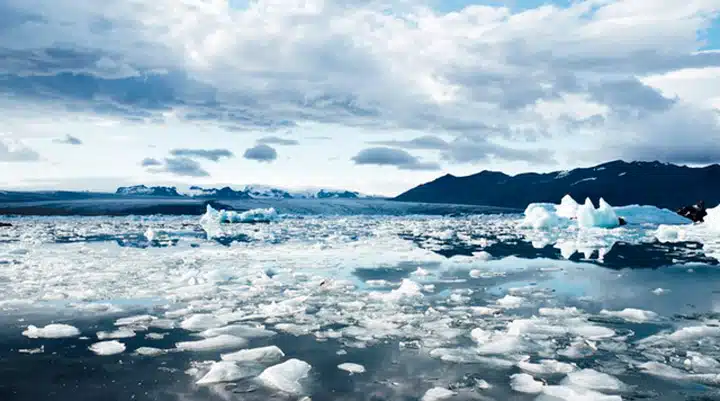 Iceland A group of clouds in the sky over a snow covered mountain
