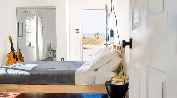 A bedroom with a bed and desk in a room
