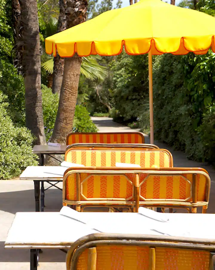 Parker A group of people sitting at a table with an umbrella