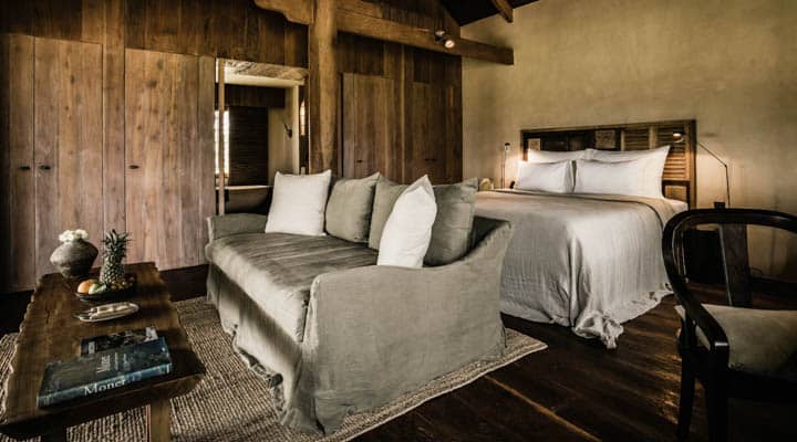 A bedroom with a bed and a chair in a room