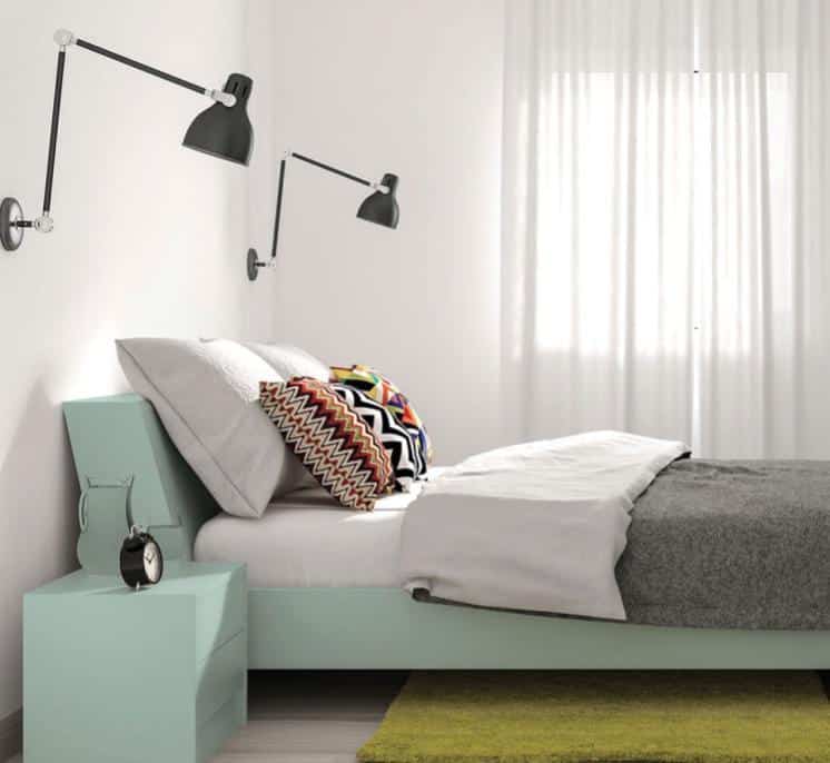 A bedroom with a bed and desk in a room