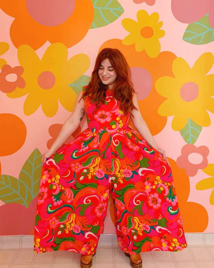 A woman standing in front of a colorful dress