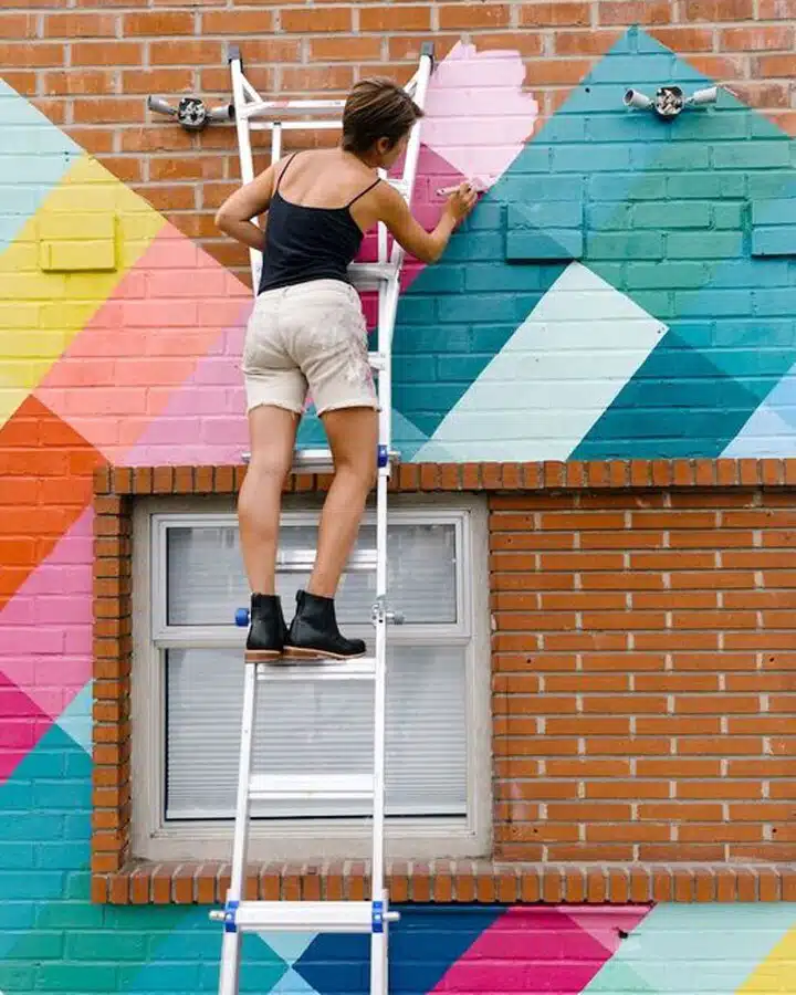 SkandiaShafer_Helm_Steph-6441 A young girl jumping on a brick building