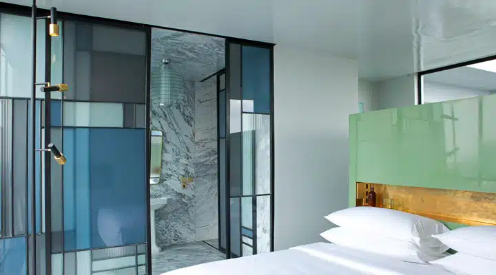 Undine-Prohl40 Un dormitorio con cama y puerta de cristal