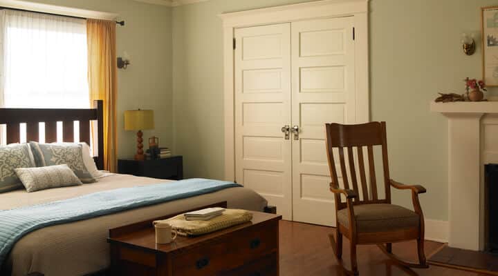 Un dormitorio con una cama y una silla en una habitación