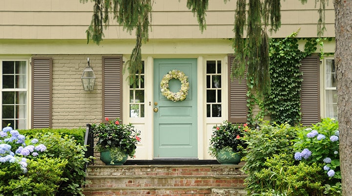 A close up of a flower garden in front of a house