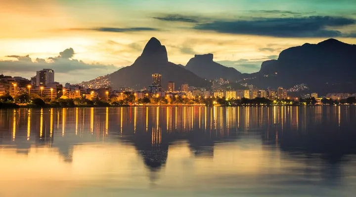 iStock_63748171_LARGE A sunset over a body of water with a city in the background