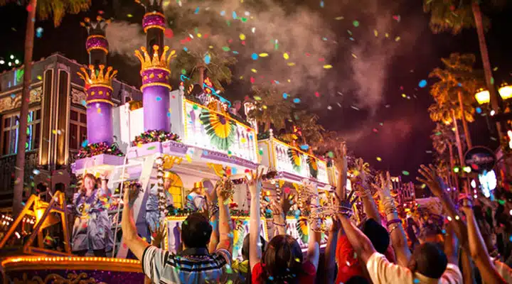 universal-mardi-gras Un grupo de personas actúa en un escenario frente a un edificio