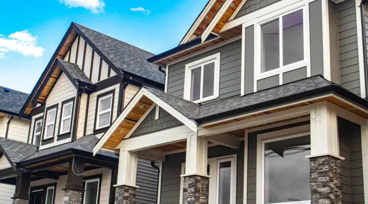 Brand new houses just after construction on real estate market. A group of people in front of a brick building