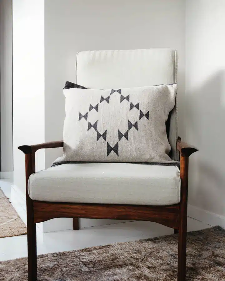 Scandi style armchair with cushion A living room filled with furniture and a lamp