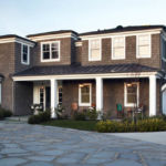 A large brick building with grass in front of a house