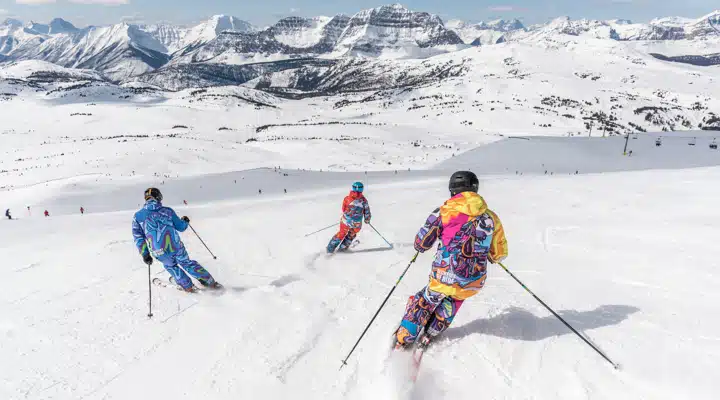 Un grupo de personas desciende esquiando por una ladera nevada
