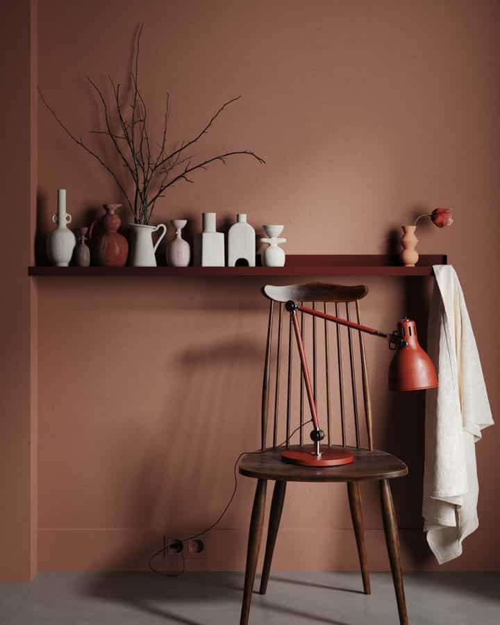 A vase of flowers is sitting on the corner of a room