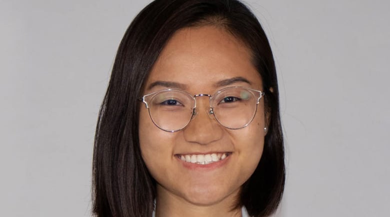 A woman wearing glasses and smiling at the camera