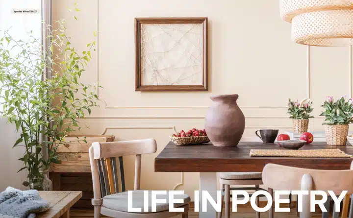 Una habitación llena de muebles y un jarrón de flores sobre una mesa