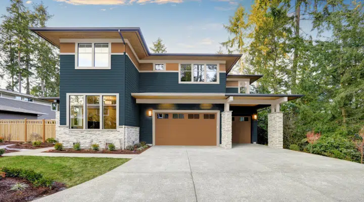 Un gran edificio de ladrillo con césped delante de una casa