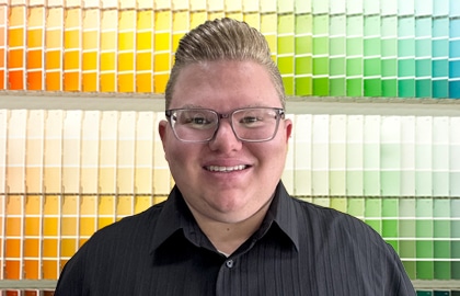 A man wearing glasses and smiling at the camera
