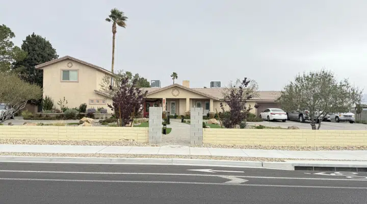 A house that has a sign on the side of a road